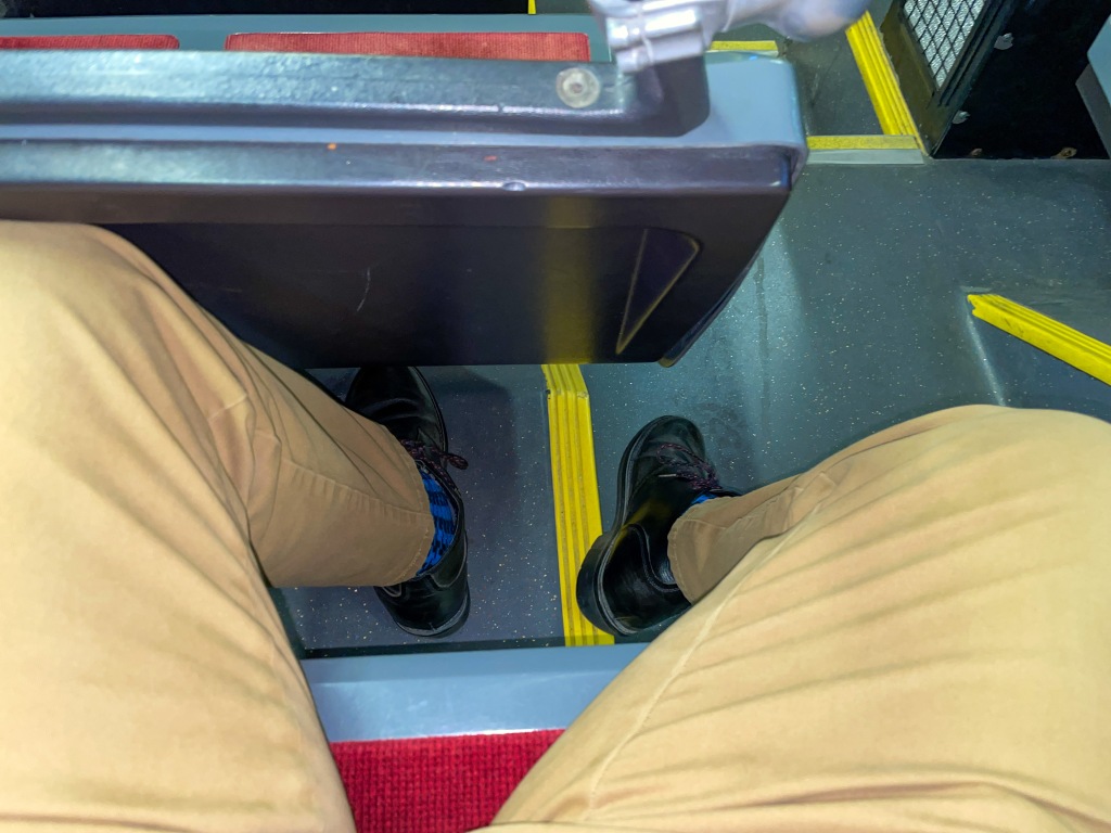 Left leg jammed against seat in front, right leg in aisle
